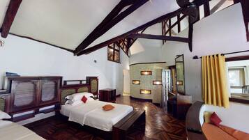 A spacious bedroom with a large bed, wooden headboard, and a built-in fireplace.