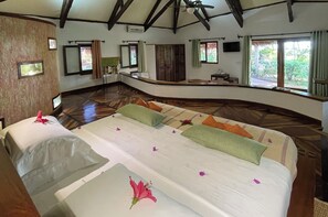 Una habitación amplia con una cama grande, techo abovedado y vistas al exterior.