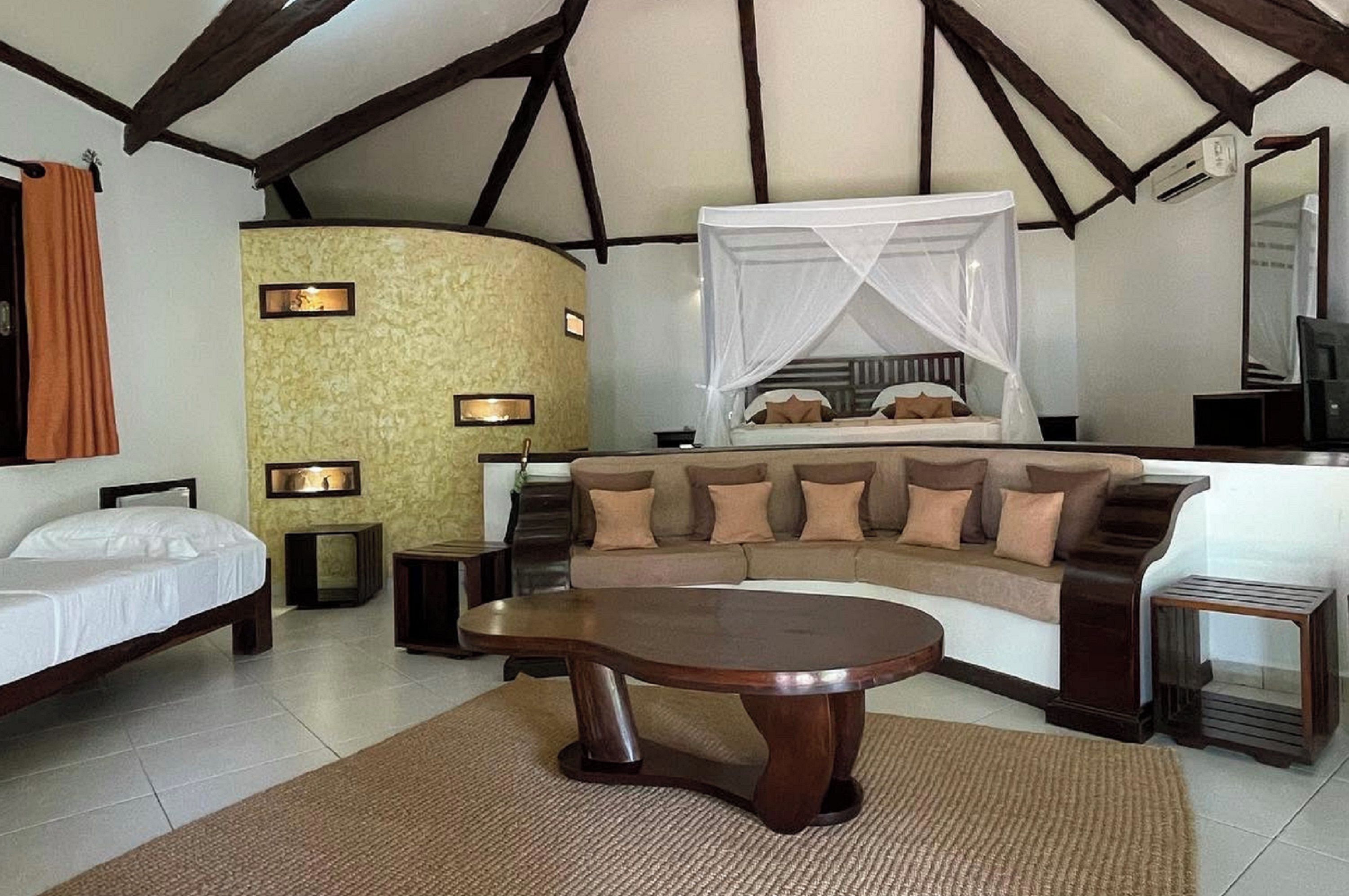 A room with a bed, a sofa, a coffee table, and a TV.