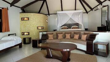 A room with a bed, a sofa, a coffee table, and a TV.