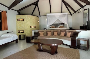 A room with a bed, a sofa, a coffee table, and a TV. - Ravintsara Wellness Hotel (Nosy Be)