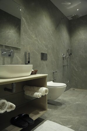 A modern bathroom with a large white sink, a toilet, and a shower area. - Tr Hotels (Ambala)