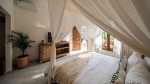 Une chambre à coucher avec un lit à baldaquin, une plante en pot, une armoire en bois et une fenêtre donnant sur un paysage verdoyant.