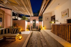 Un espace intérieur accueillant, avec un canapé, un tapis à motifs et un banc en bois.