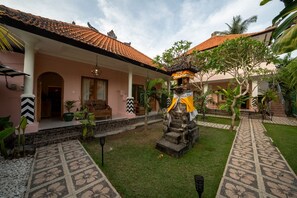 A courtyard with a tiled roof, a central statue, and a covered seating area. - Casa Coco (Lembongan Island)
