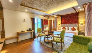 A hotel room with a large bed, two armchairs, a desk, and a sofa. - The Walnut Creek Hotel (Anantnag)