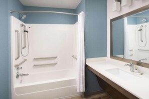 Une salle de bain avec une baignoire, une douche et un lavabo.