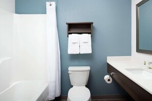 A bathroom with a bathtub, toilet, and sink. - Woodspring Suites Orlando International Drive (Orlando)