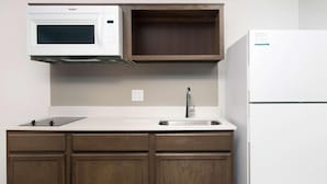 Una cocina equipada con microondas, lavaplatos y refrigerador.