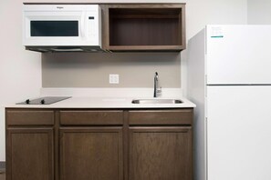 A kitchen with a microwave, sink, and refrigerator. - Woodspring Suites Orlando International Drive (Orlando)