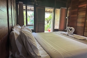 Una habitación con cama, cortinas y vistas a zonas verdes.