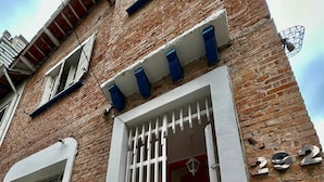 A brick building with a white door and barred entrance.