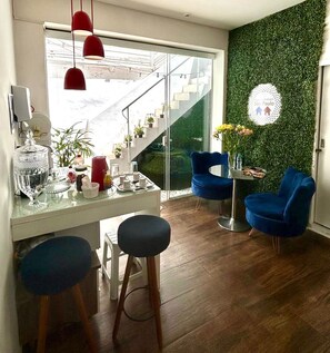 Een moderne keuken met een glazen kookeiland, rode hanglampen en een groene wand.