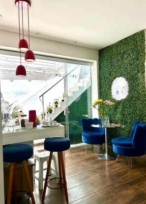 Een modern interieur met een trap, blauwe stoelen en een groene wand.