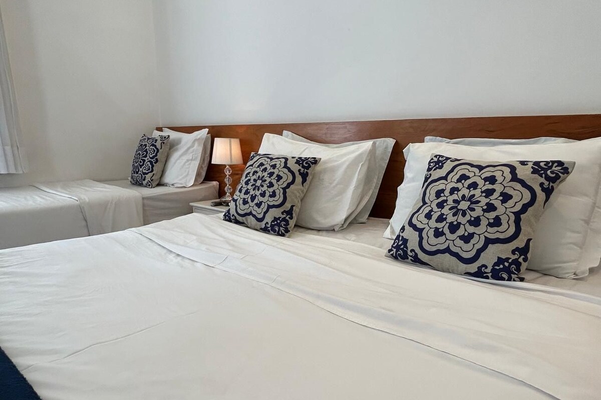 Een hotelkamer met een groot bed, twee nachtkastjes en een houten hoofdbord.