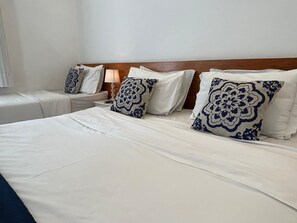 Een hotelkamer met een groot bed, twee nachtkastjes en een houten hoofdbord.