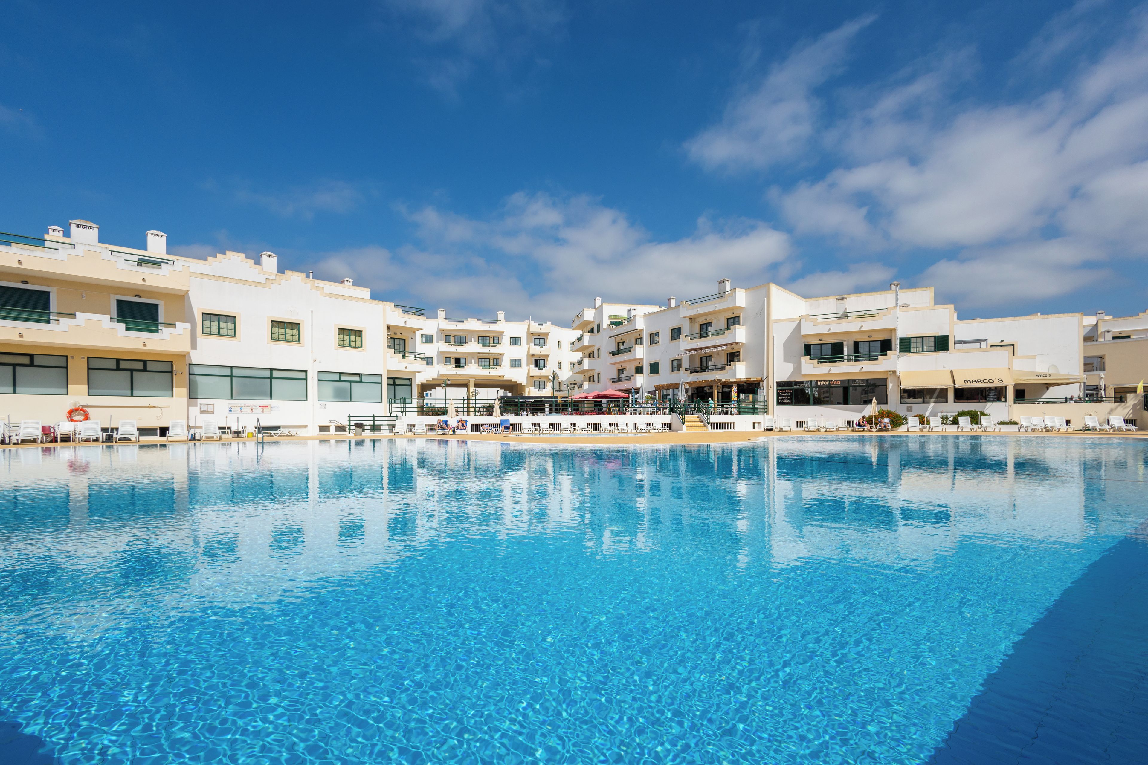 A swimming pool with modern buildings in the background.