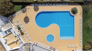 An aerial view of a hotel with a large pool, multiple lounge areas, and a landscaped garden. - Dunas Hostel & Guesthouse (Portimão)