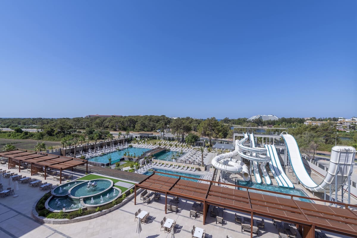 A resort with a large pool, water slides, and outdoor seating areas.