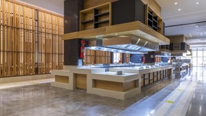 A modern kitchen area with a central island, wooden paneling on the left, and a polished floor.