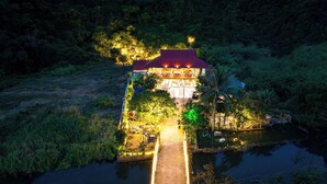 Un hôtel situé au bord de la rivière, doté d’un quai et entouré d’une forêt dense.