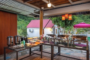 Un buffet avec de la nourriture, un barbecue et un espace pour s'asseoir.