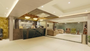 A modern hotel lobby with a reception desk, seating area, and decorative elements. - Hotel Sakura By Maps, Huda City Center (Gurugram)
