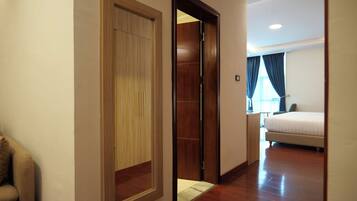 A hotel room with a wooden wardrobe, a bed, and a small desk.