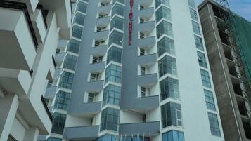 Een modern hotel met meerdere verdiepingen, een opvallende ingang, grote ramen en vlaggen.