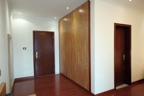 A hallway with wooden doors and a wooden wardrobe. - Crescent International Hotel Bole (Addis Ababa)