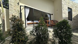 Una habitación moderna con un ventanal grande, una cama y una mesita.