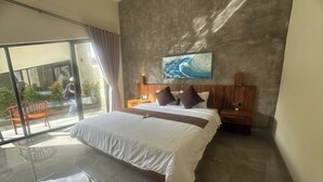 A modern hotel room with a large bed, a wooden headboard, a painting of a wave, and a balcony with a view. - Nawan Nusa Dua Bali By Zuzu (Kutuh)