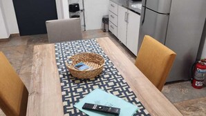 A small kitchenette with a microwave, refrigerator, and cabinets. There's a door marked "SALIDA" and a fire extinguisher near the fridge. - Comarca Sur (Ushuaia)