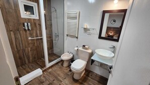 A bathroom with a shower, two toilets, a bidet, a sink, and a mirror. - Comarca Sur (Ushuaia)