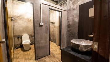 Un bagno moderno con lavabo in marmo, un water e pavimento in legno.
