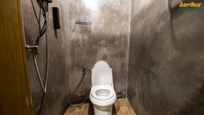 A compact, modern bathroom with a white toilet, a shower head, and a small vent on the wall. - Another High Away Co.,ltd (Bang Kruai)