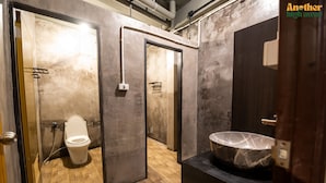 A modern bathroom with a marble sink, a toilet, and a wooden floor. - Another High Away Co.,ltd (Bang Kruai)