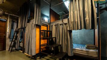 Una camera compatta con un letto a castello, un piccolo tavolo e una scala.