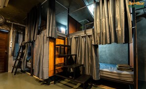 A compact room with a bunk bed, a small table, and a ladder. - Another High Away Co.,ltd (Bang Kruai)