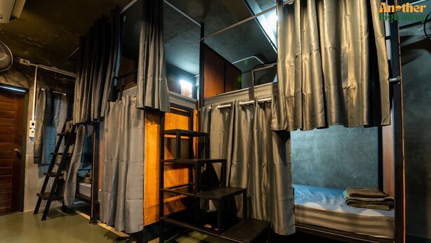 A compact room with a bunk bed, a small table, and a ladder. - Another High Away Co.,ltd (Bang Kruai)