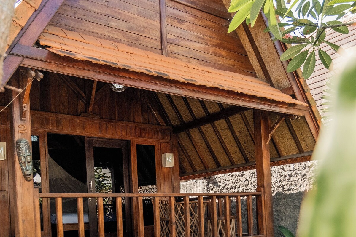 Ein Holzhaus mit Balkon und Blick auf einen Swimmingpool.