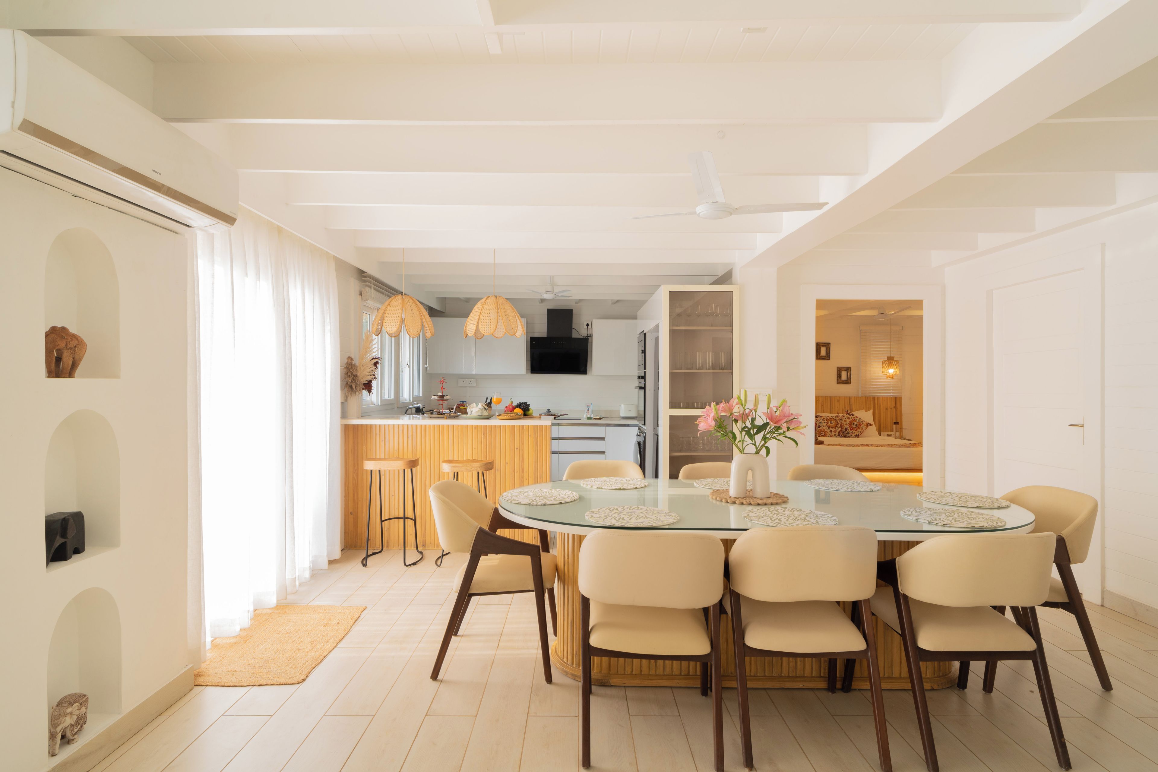 Una cocina moderna con armarios blancos, una isla central e iluminación colgante.