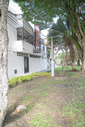 Un hotel de diseño moderno, con un cartel llamativo y un jardín bien cuidado.