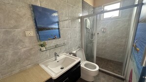 A bathroom with a large sink, toilet, and glass-enclosed shower. - Abc Hostel By Zuzu (Seri Kembangan)