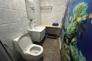 Un baño con inodoro, lavamanos y ducha.