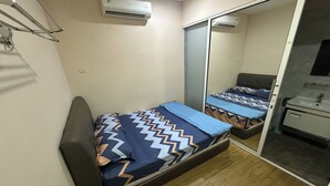 Un dormitorio pequeño con cama, armario y espejo.