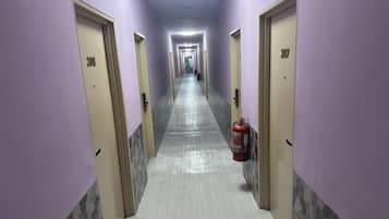 A hallway with doors numbered 200 and 207, a fire extinguisher, and a tiled floor.