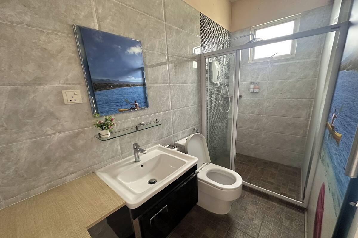 Een badkamer met een wastafel, toilet en douchecabine met glazen wanden.