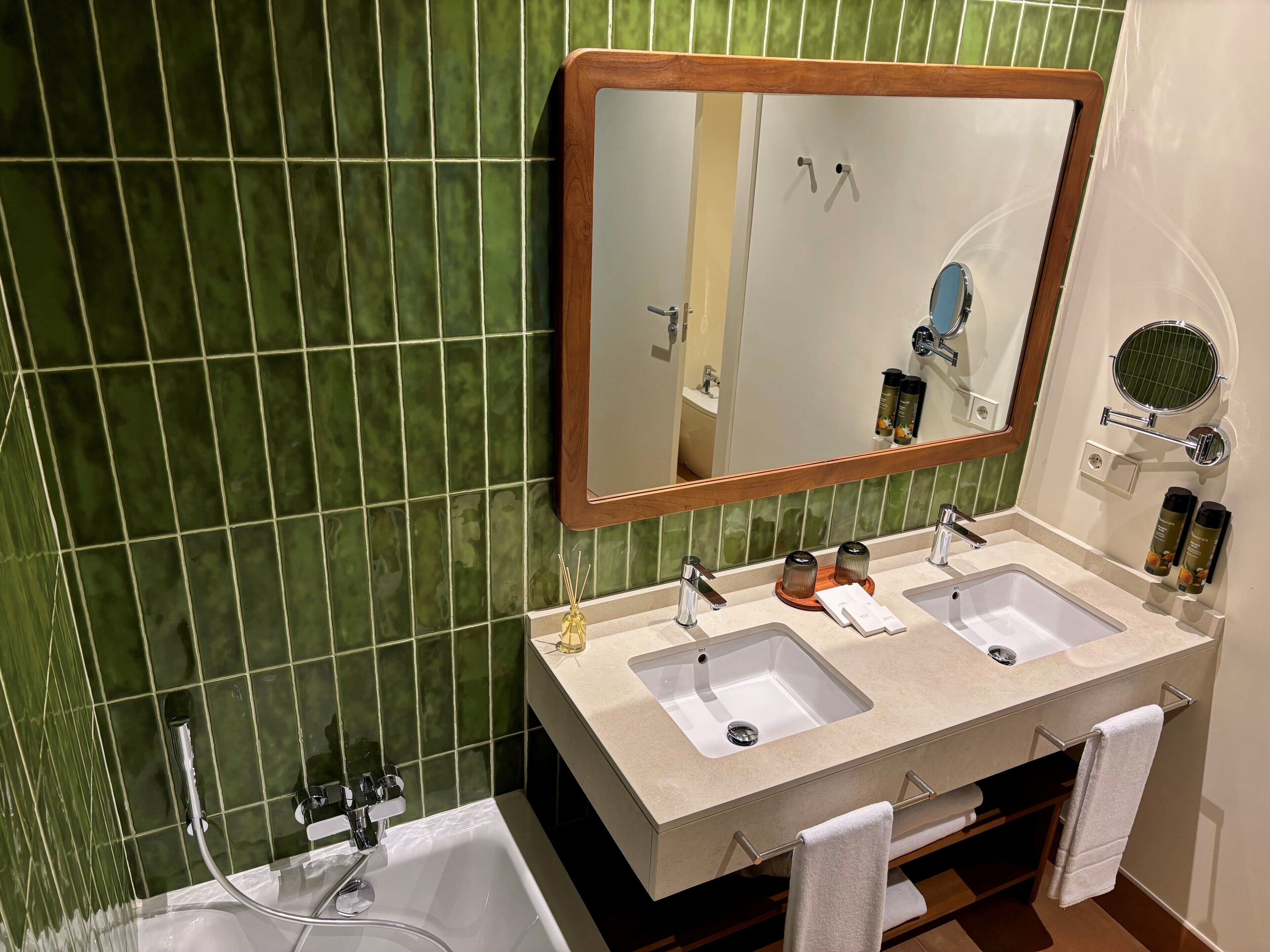 Une salle de bain avec deux lavabos, un grand miroir et une baignoire.