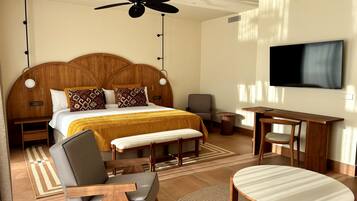 Een hotelkamer met een groot bed, een bureau, een stoel, een televisie en een plafondventilator.